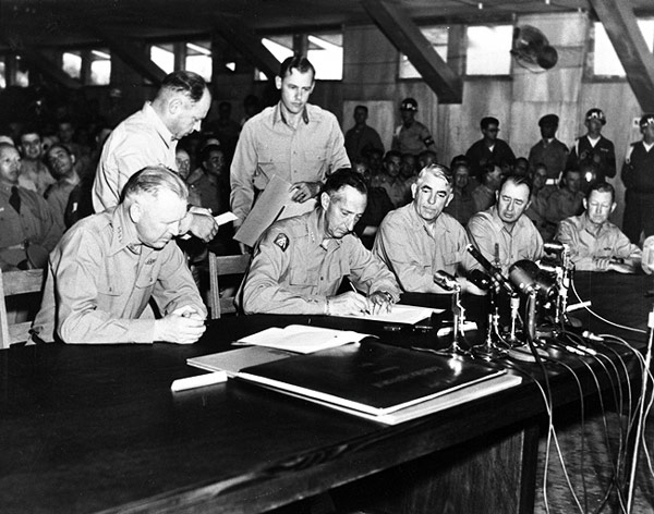 Photo: General Mark W. Clark, Far East commander, signs the Korean armistice