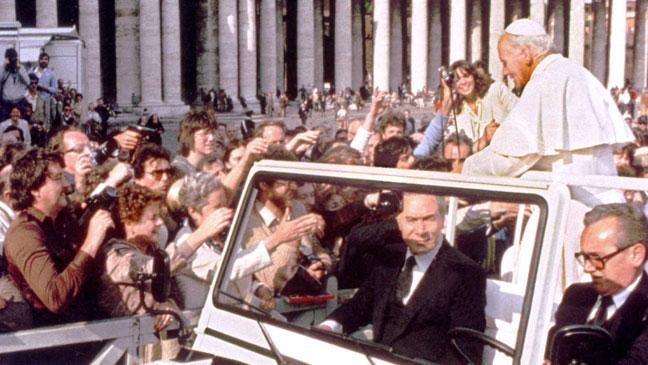 A gun appears from the crowd as Pope John Paul II addresses crowds in St Peter's